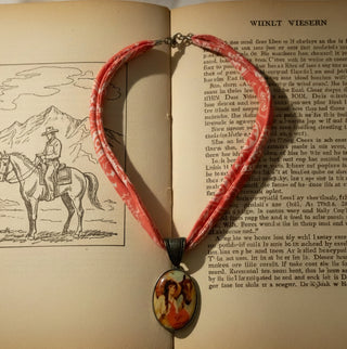 Western bandana-style double cord necklace with a vintage cowgirl art pendant.