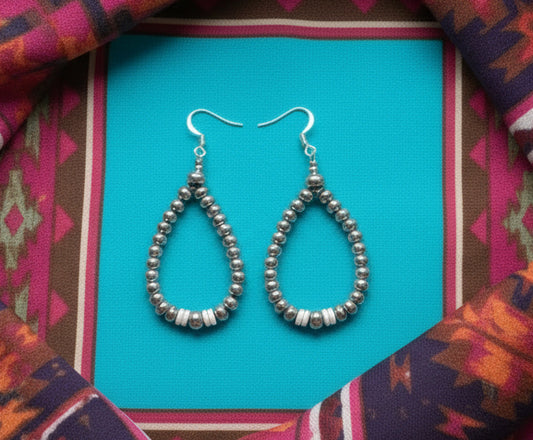 Sterling silver teardrop earrings with graduated saucer pearls and pink conch heishi bead center, shown on french hooks with lightweight design and natural color variation.