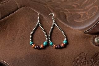 Long teardrop earrings made with small sterling silver pearls and turquoise, orange, and purple spiny oyster beads on French hooks.