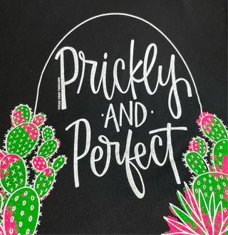 A graphic tee with the text 'Prickly and Perfect' surrounded by stylized cactus illustrations.