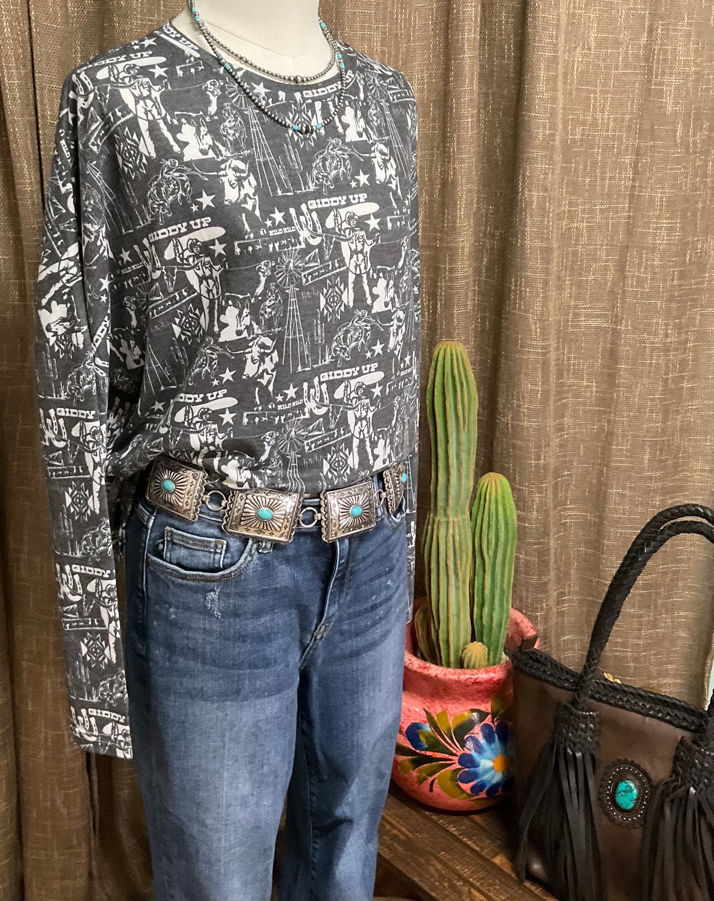 Charcoal grey long-sleeve top with a western collage print, relaxed fit, made from a 60% cotton and 40% polyester blend.