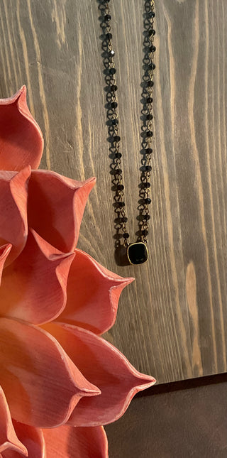 Close up of cushion cut crystal pendant on delicate beaded chain