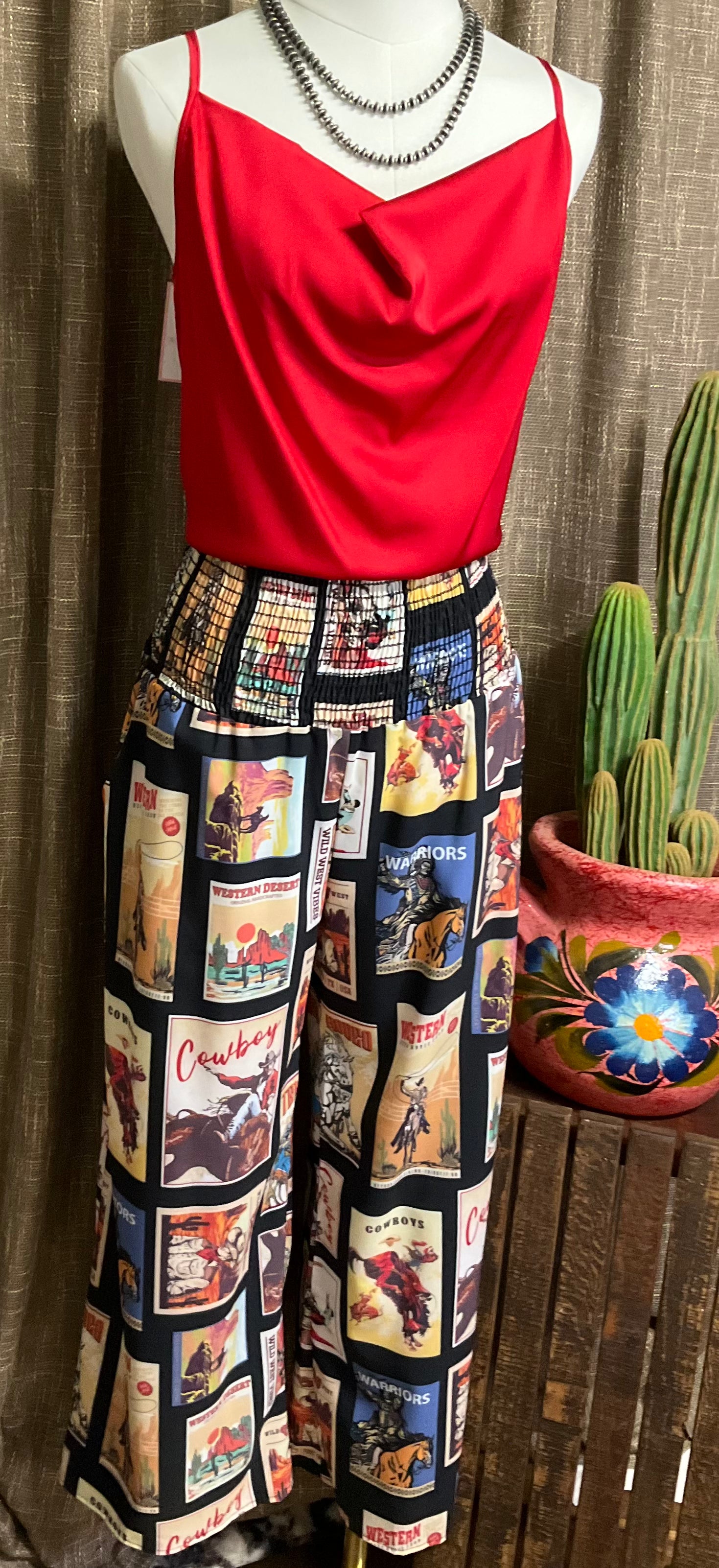 Black palazzo pants with vintage western graphics, featuring a smocked elastic waist. The pants have a wide-leg flowy fit