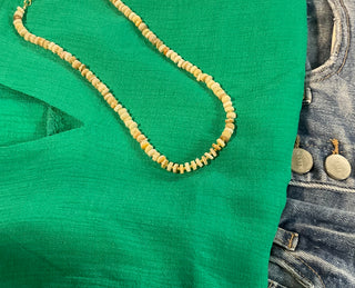 Neutral beaded necklace with gold-toned spacers, approx. 16” with 2” extender, styled as a lightweight everyday layering piece.