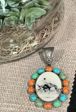 Vintage-inspired oval pendant featuring a bronc rider graphic, surrounded by turquoise or multicolored stones