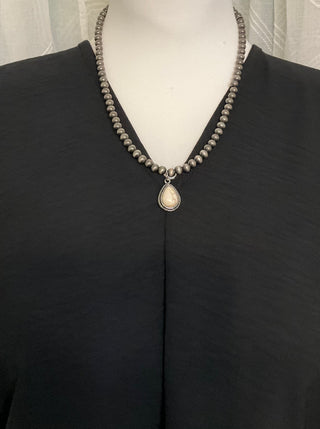 Statement necklace with silver pearl strand and bold teardrop stone pendant