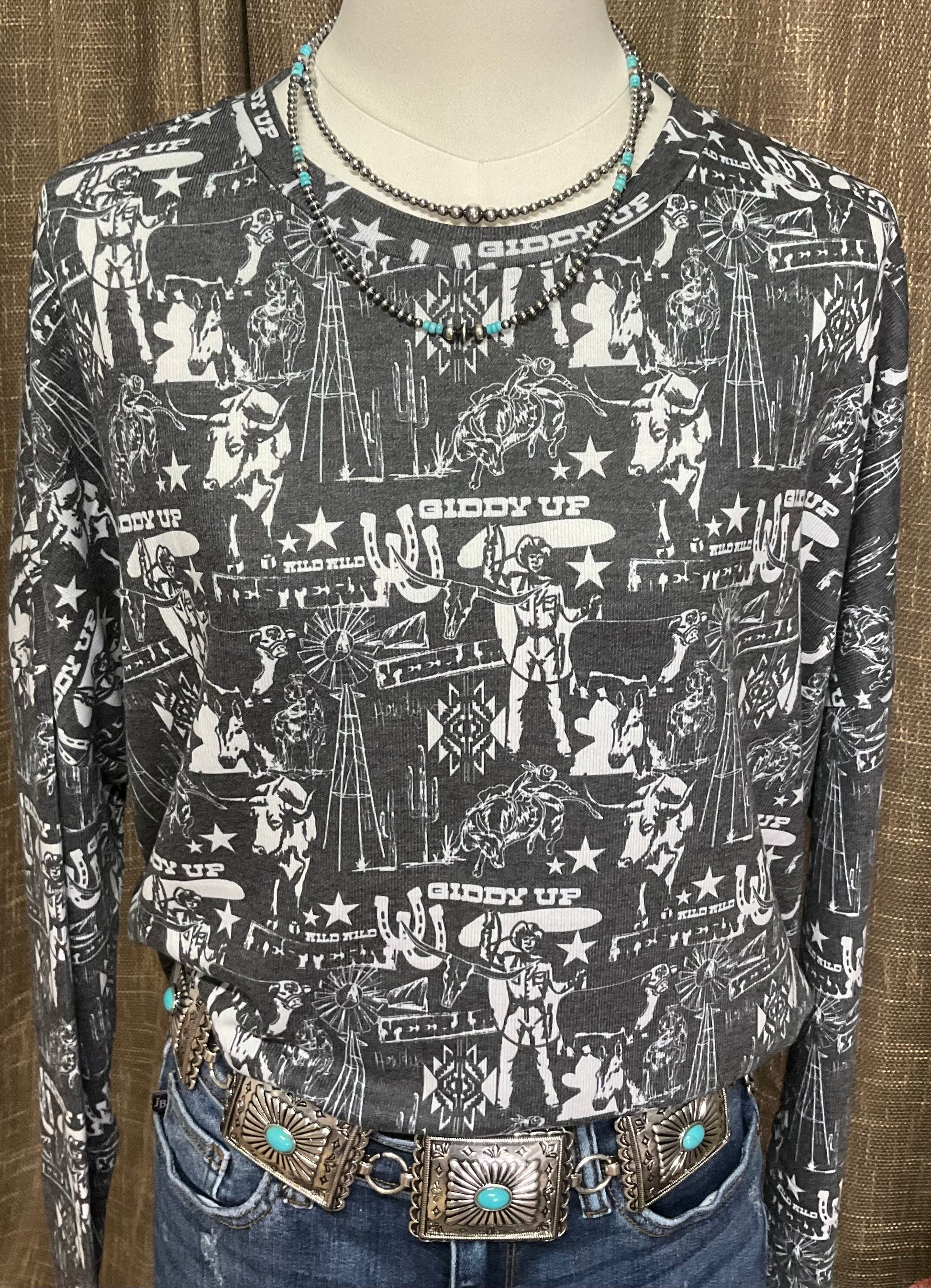 Charcoal grey long-sleeve top with a western collage print, relaxed fit, made from a 60% cotton and 40% polyester blend.