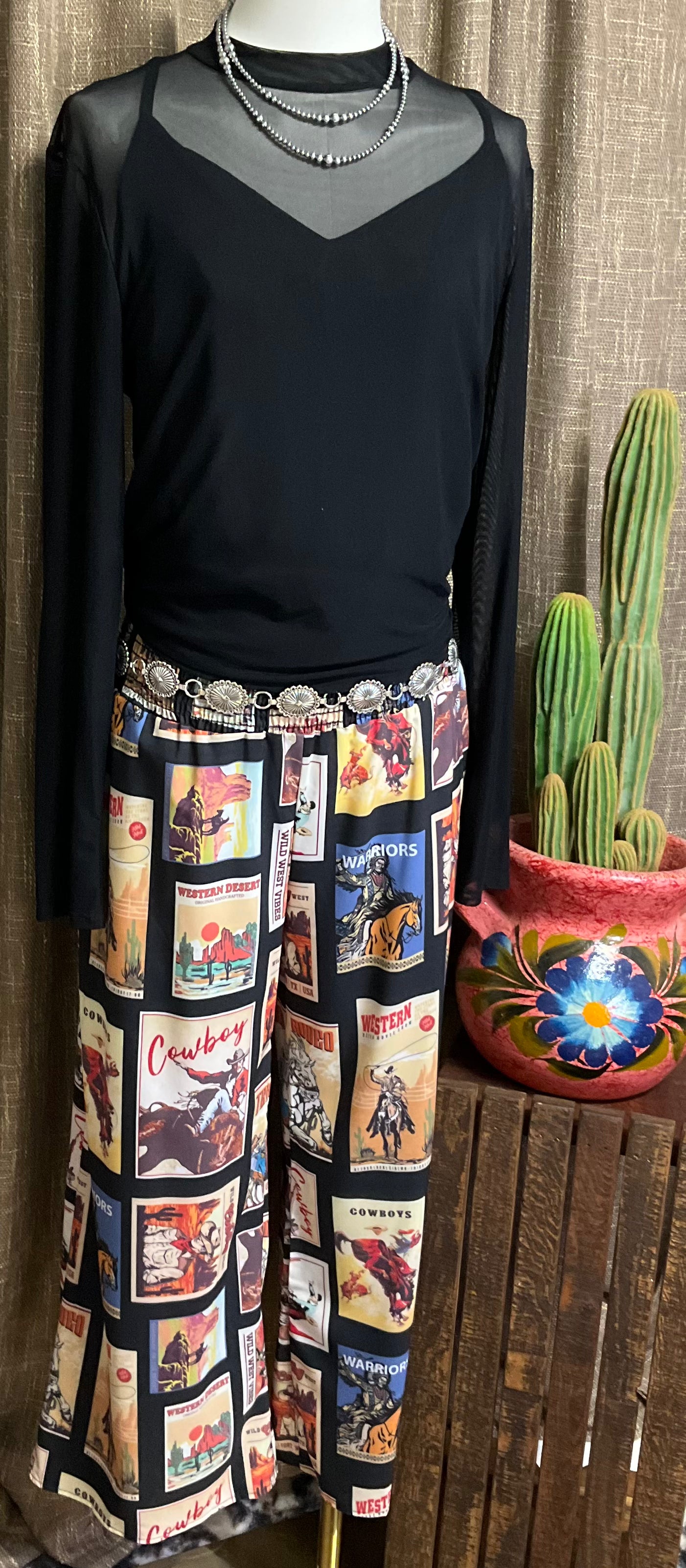 Black palazzo pants with vintage western graphics, featuring a smocked elastic waist. The pants have a wide-leg flowy fit