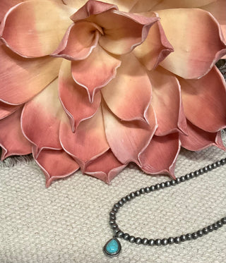 Statement necklace with silver pearl strand and bold teardrop stone pendant