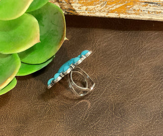 Silver-tone adjustable ring with triangle turquoise center stone and surrounding oval turquoise accents.