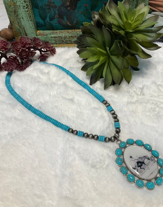 Oval pendant necklace with black and white rodeo image and turquoise accents close up