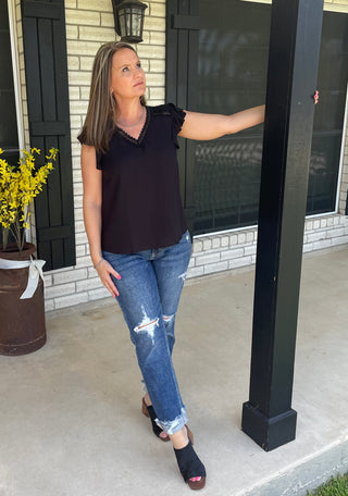 Dressy black top styled with denim for an elevated everyday outfit
