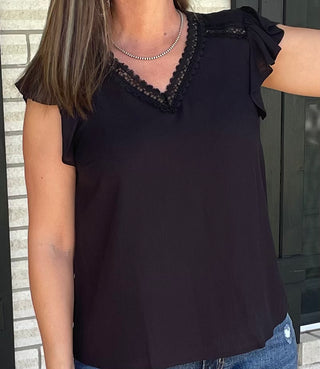 Women's black blouse with lace neckline detail and flutter sleeves