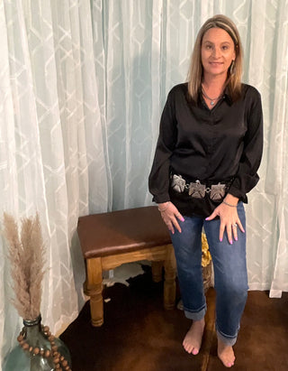 Dressy satin blouse paired with western accessories and denim