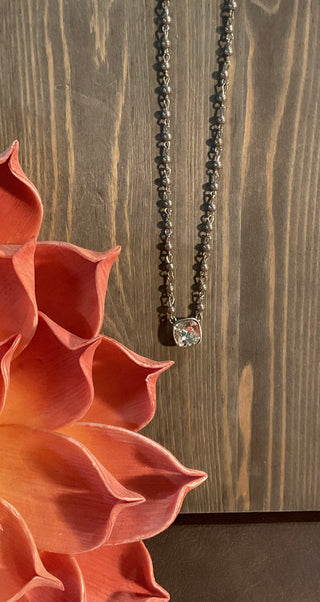 Close up of cushion cut crystal pendant on delicate beaded chain