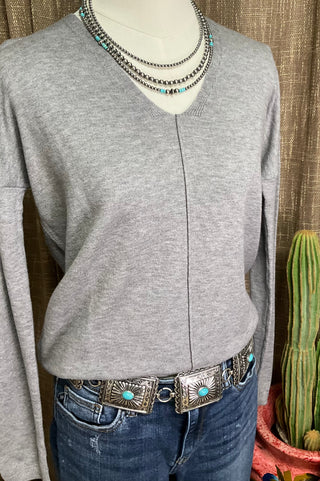 Women’s neutral v-neck sweater with exposed front seam and split hem in oatmeal and grey