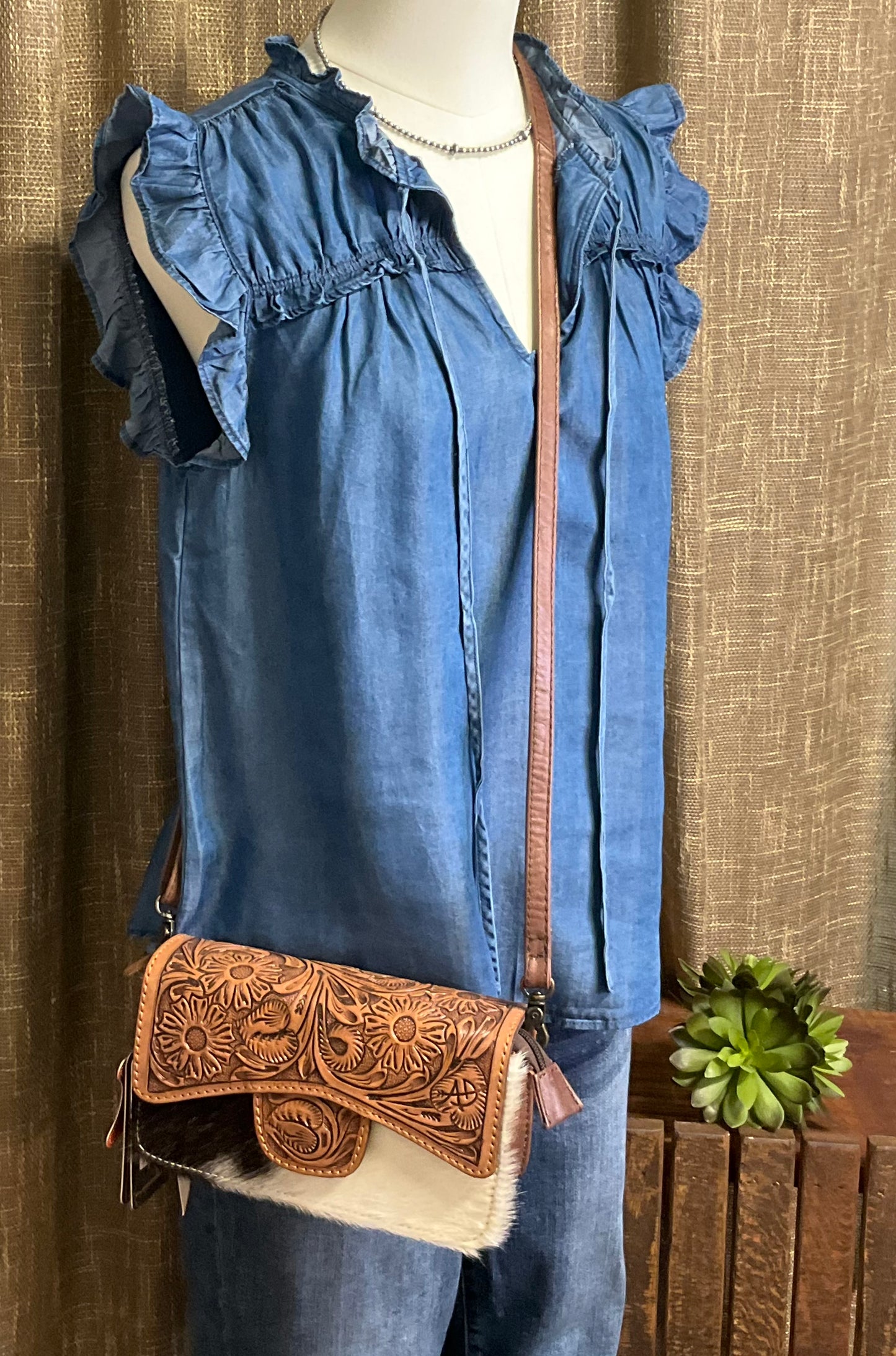 Jenna Chambray Blouse in soft blue lyocell—sleeveless top with high neckline, feminine neck tie, keyhole front detail, ruffle trim, and gently ruched yoke for subtle texture and charm.