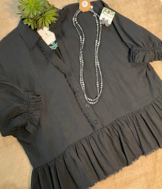 Harlie Linen Top in a lightweight, breathable linen fabric featuring a button-up front, 3/4 sleeves, and a ruffled bottom hem with frayed edging for a relaxed yet chic look. Designed for versatile styling across seasons.