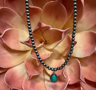 Statement necklace with silver pearl strand and bold teardrop stone pendant