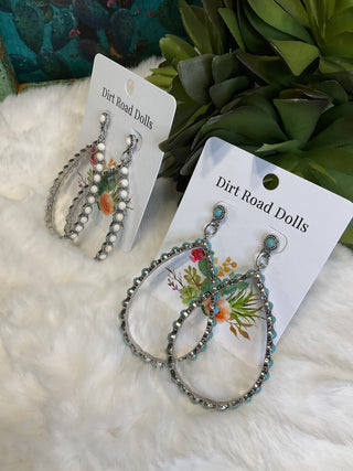 Silver-tone teardrop earrings with ornate detailing and colored center stones, available in white and turquoise; approx. 2.75" long