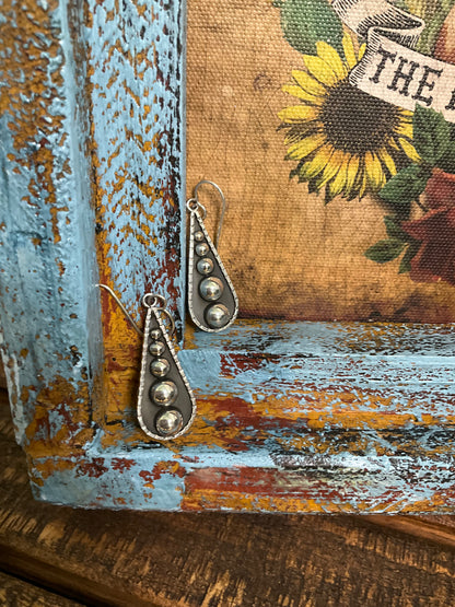 Sterling silver teardrop earrings featuring a graduated dot pattern with French hooks