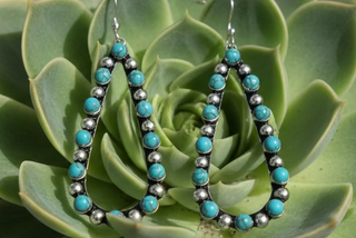 Silver-tone teardrop earrings with textured beaded detail and turquoise-colored accents