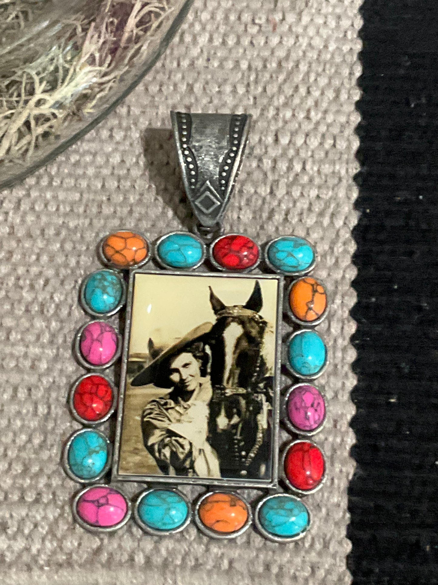 Vintage cowgirl pendant with multicolored stone border, approx. 3.5 inches long, designed to slide onto necklaces or cords.