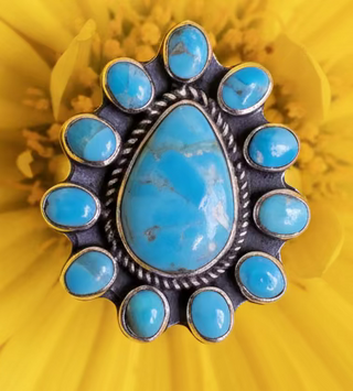 Minot Sterling & Turquoise Ring with a large teardrop turquoise center stone and surrounding oval turquoise stones set in sterling silver