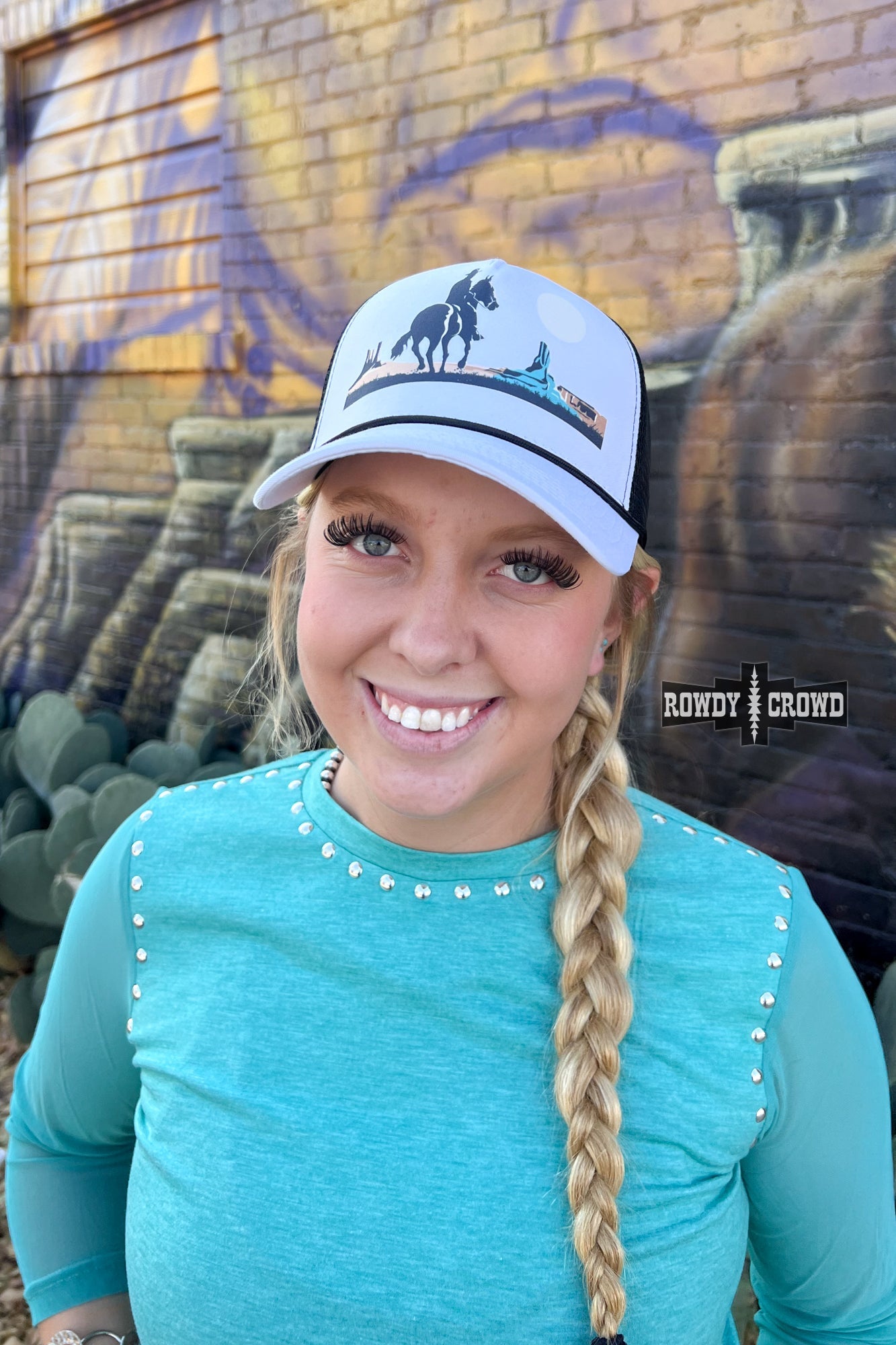 white and black trucker cap with horseback cowboy in desert scene