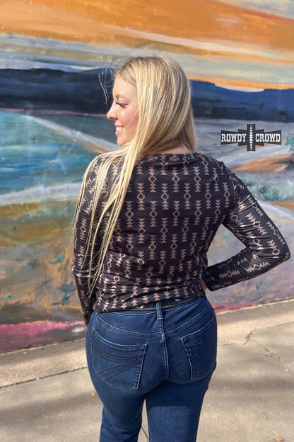 black long sleeve v neck top with tan Aztec print and concho accents at neckline