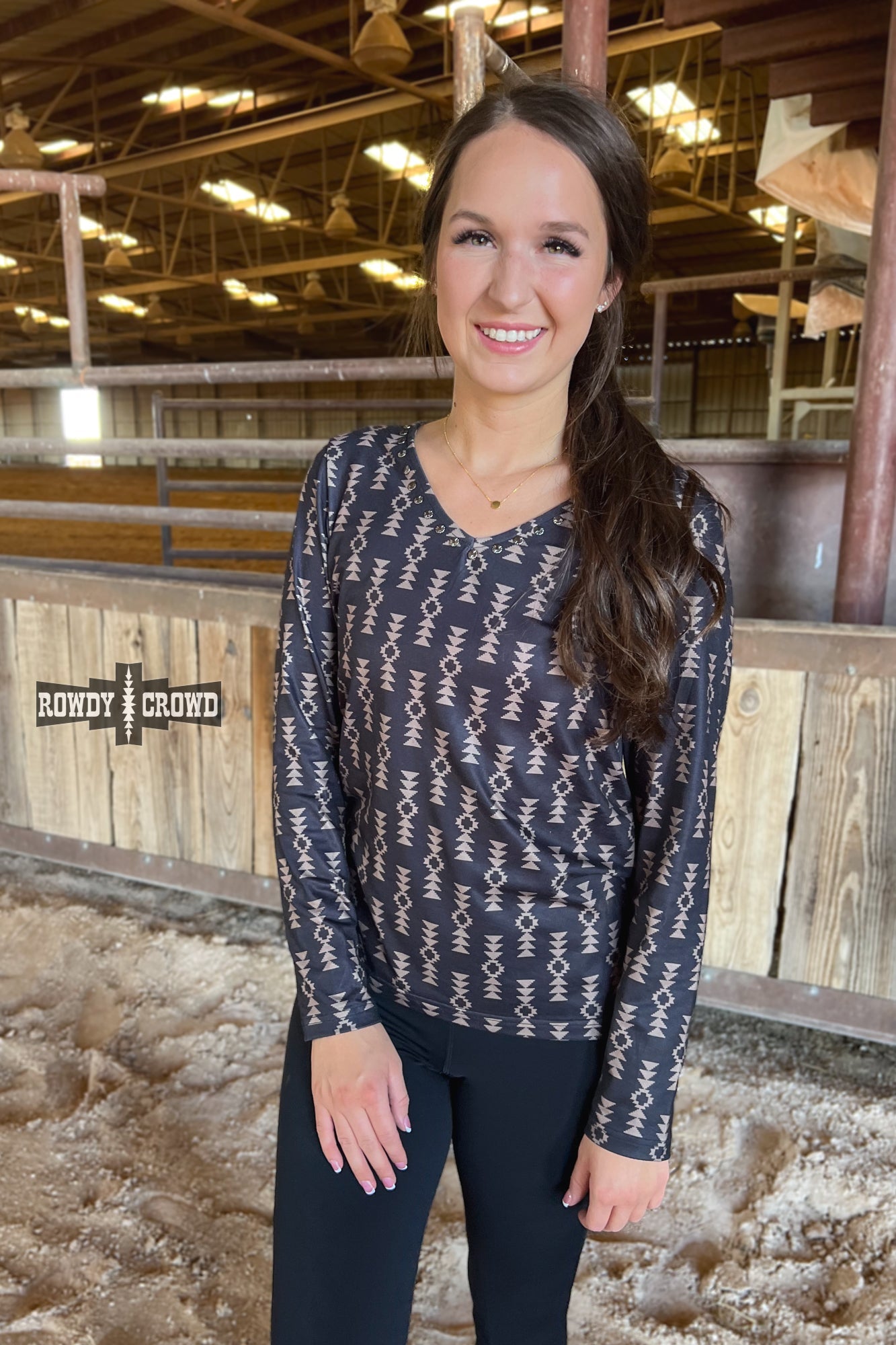 black long sleeve v neck top with tan Aztec print and concho accents at neckline