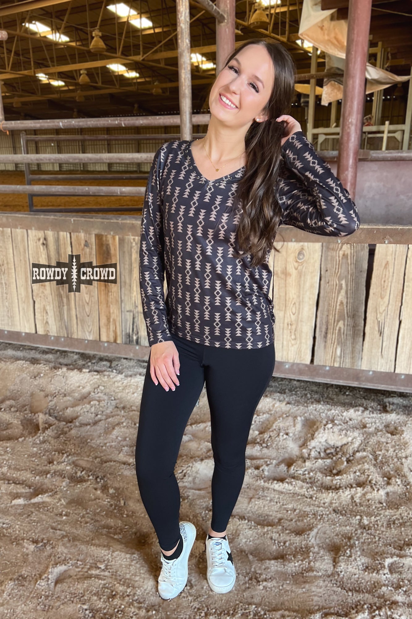 black long sleeve v neck top with tan Aztec print and concho accents at neckline