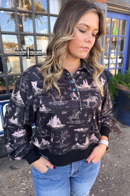 black collared long sleeve top with cream colored cowboy on horse pattern with mountains.  cuff sleeve and bottom. three turquoise snaps