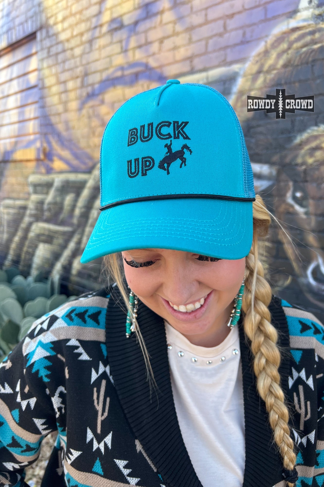 teal trucker cap with black bucking horse graphic and words BUCK UP