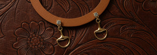 Lightweight equestrian-inspired gold drop earrings featuring a horse bit design