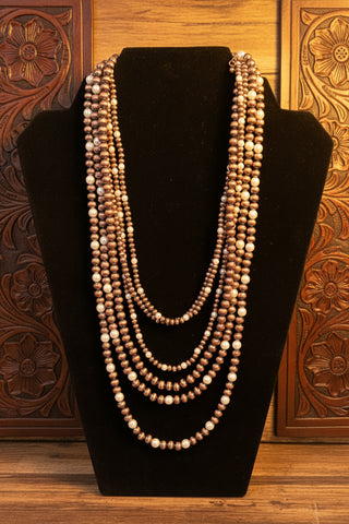 Six strand layered necklace with copper toned beads and faux pearl accents