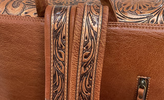 Western backpack with floral tooled leather, adjustable straps, and organized interior storage