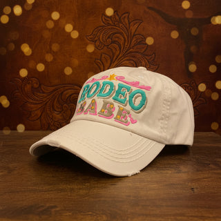 Distressed cream baseball cap featuring Rodeo Babe embroidery and adjustable back.