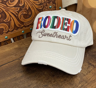 Cream Rodeo Sweetheart embroidered baseball cap with colorful serape-inspired lettering.