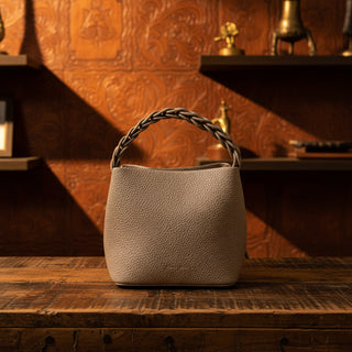 Pebbled bucket bag with braided top handle and adjustable crossbody strap
